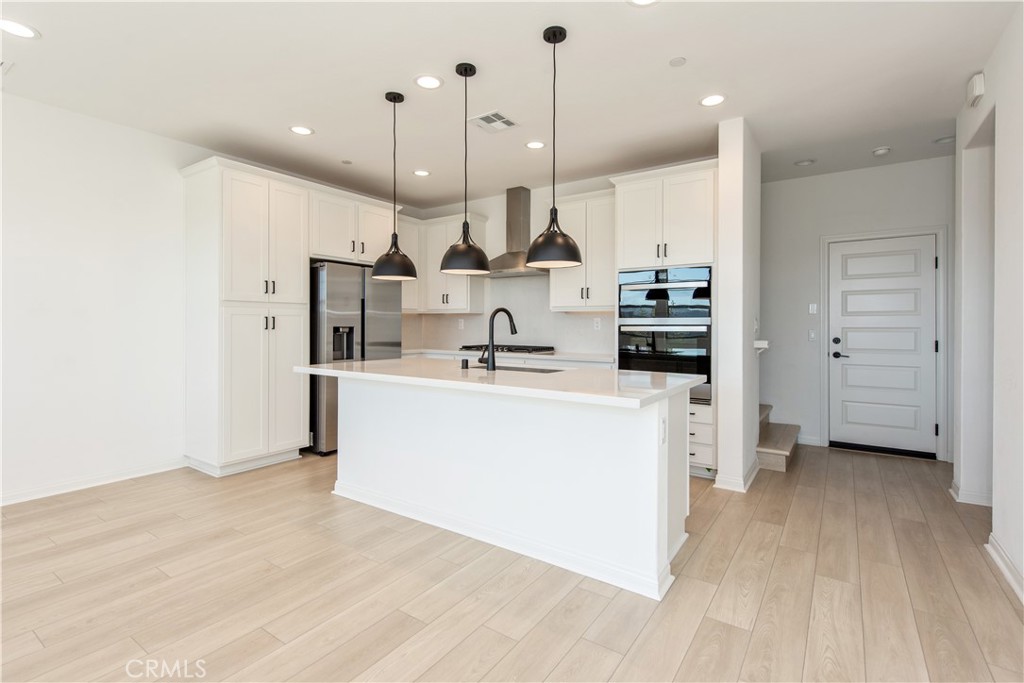 781 Cornelia Way Rancho Mission Viejo, CA 92694 - Photo 7 of 24 a view of kitchen with stainless steel appliances kitchen island a stove a sink a refrigerator and a counter top space