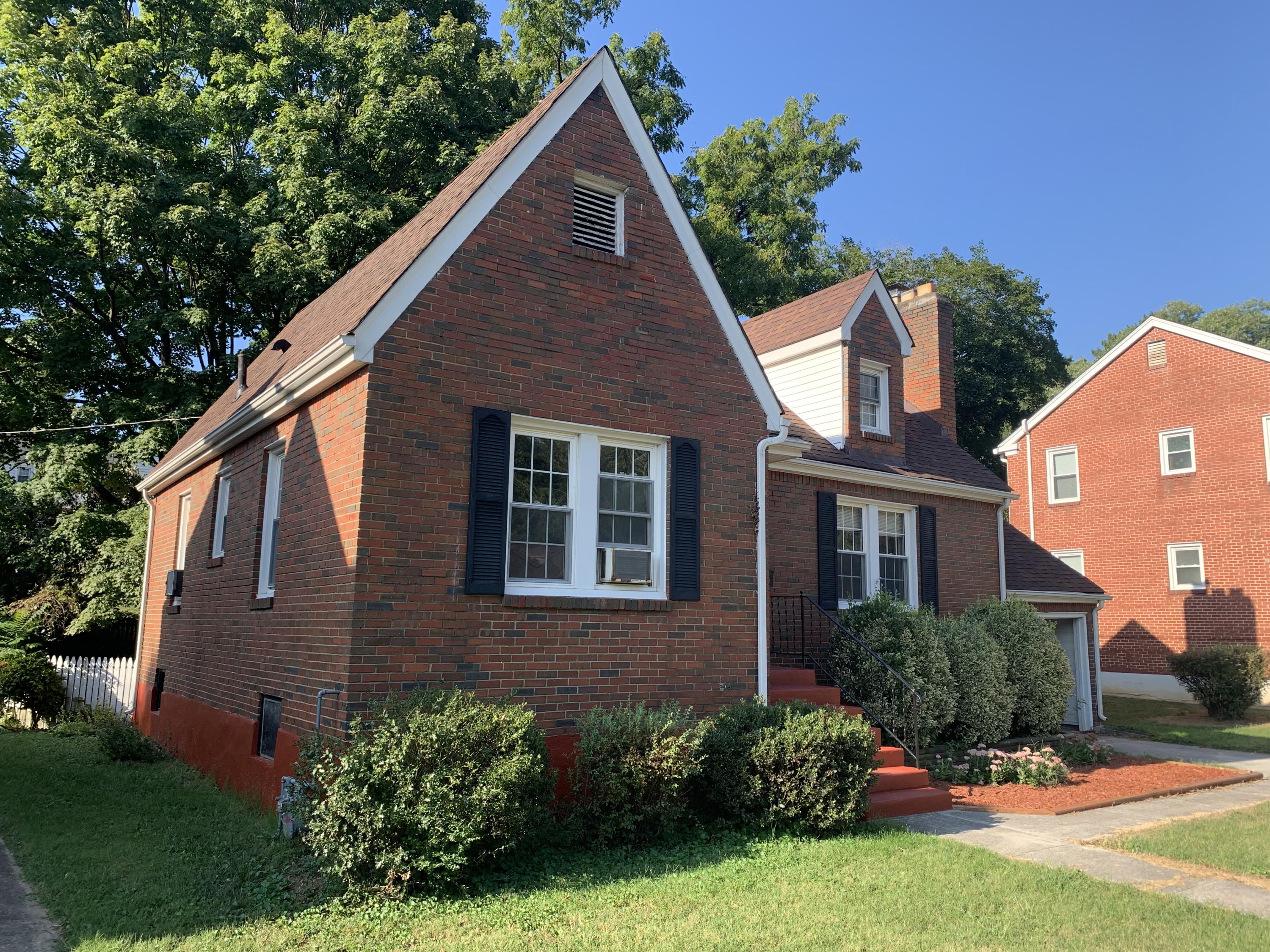 1668 Brandon Avenue Southwest Roanoke, VA 24015 - Photo 2 of 24 a view of a house with brick walls and a yard with plants