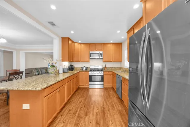 a kitchen with granite countertop wooden cabinets stainless steel appliances and a window