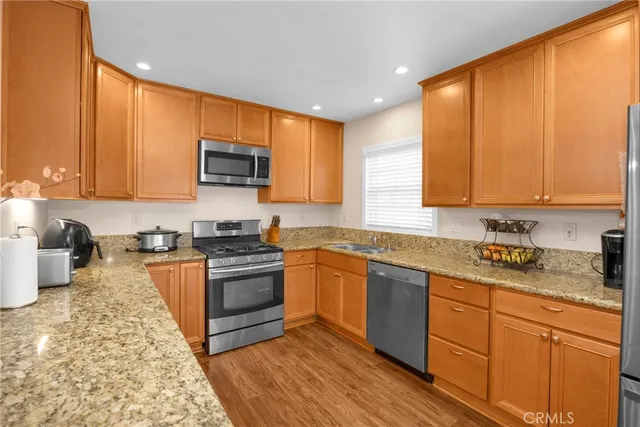 a kitchen with granite countertop cabinets sink and wooden floor