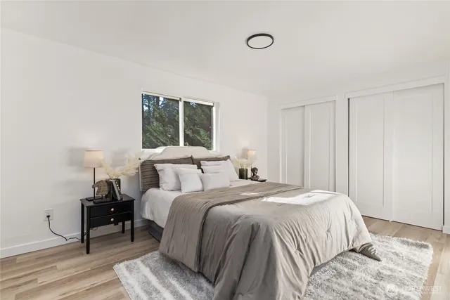 a bedroom with a bed and wooden floor