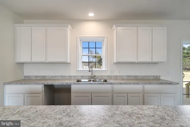 a kitchen with a sink cabinets and window