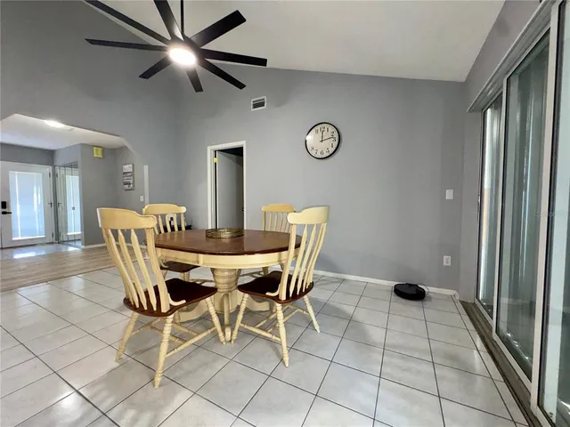 a view of a dining room with furniture and a chandelier fan