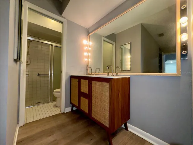 a bathroom with a mirror a shower and a sink