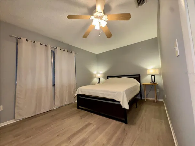 a spacious bedroom with a bed and a chandelier