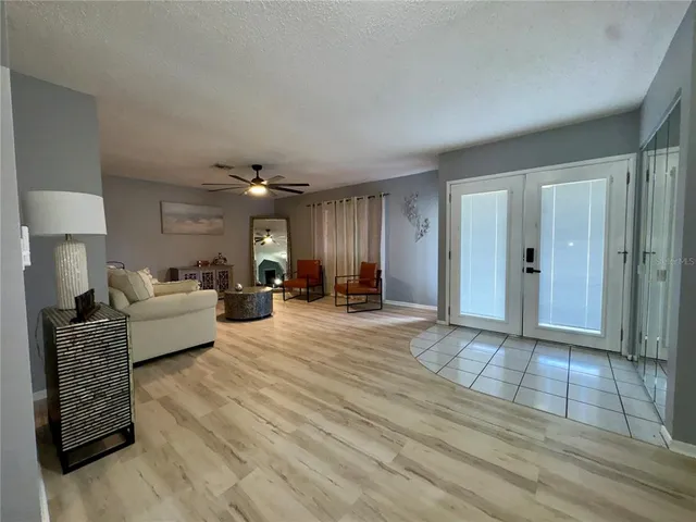 a living room with furniture a lamp and wooden floor