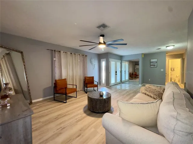 a living room with furniture a flat screen tv and a window