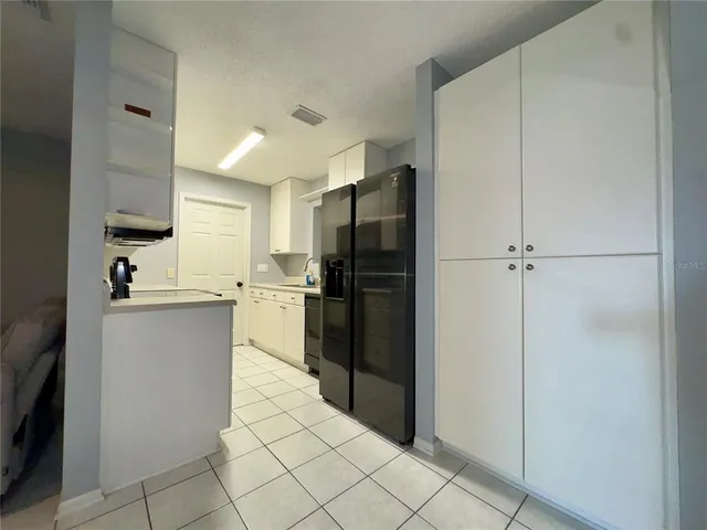 a kitchen with a refrigerator and cabinets