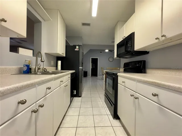 a kitchen with stainless steel appliances kitchen island granite countertop a sink a stove top oven and cabinets