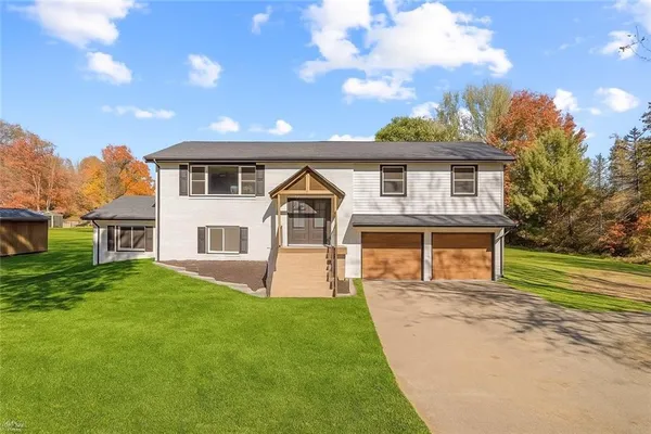 a front view of a house with a yard and trees