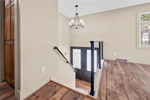 a view of a hallway with wooden floor and staircase