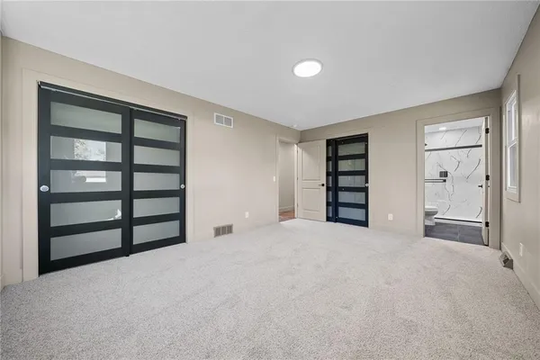 a view of an empty room with a closet and cabinet