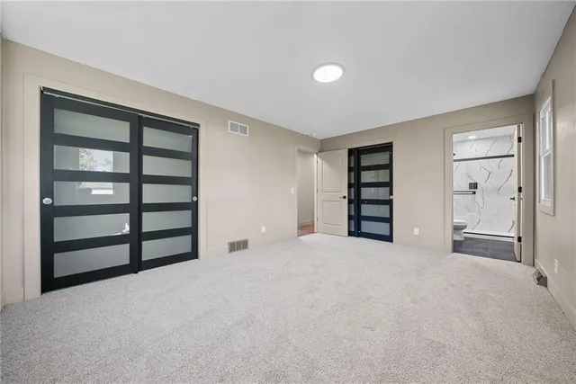 a view of an empty room with a closet and cabinet