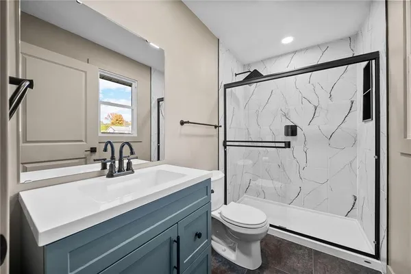 a bathroom with a sink a toilet and shower