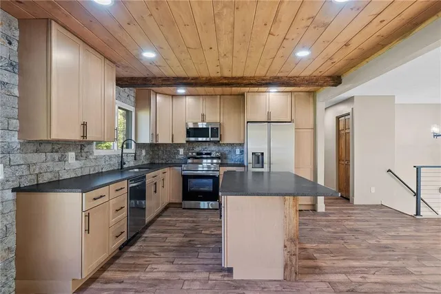 a large kitchen with stainless steel appliances granite countertop a stove a sink dishwasher and a refrigerator