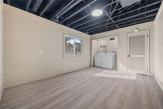 a view of empty room with wooden floor and windows