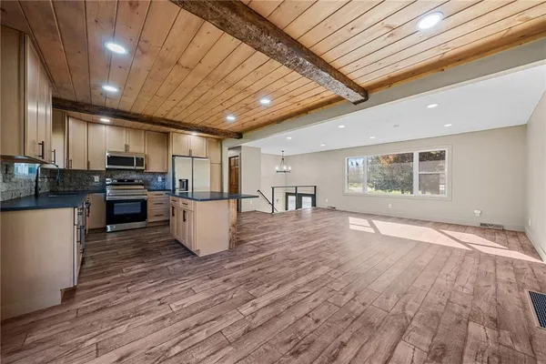 a view of kitchen with microwave a stove and wooden floors