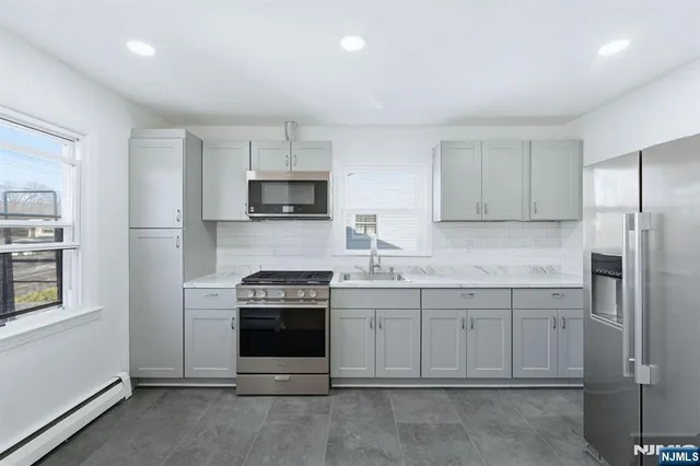 a kitchen with cabinets appliances and a window