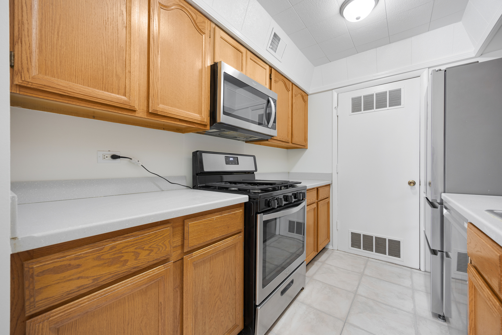 1724 Fayette Walk, Unit J Hoffman Estates, IL 60169 - Photo 10 of 15 a kitchen with stainless steel appliances granite countertop a stove and a microwave