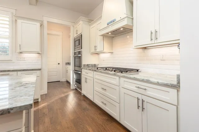 a view of a kitchen with cabinets and wooden floor