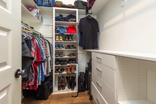 a view of walk in closet with clothes and shoes