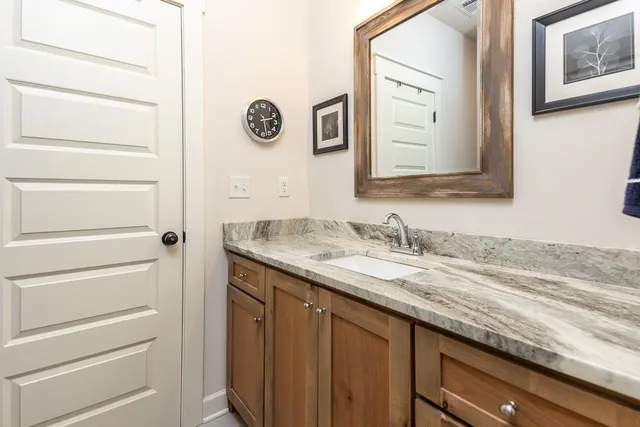 a bathroom with a granite countertop sink and a mirror
