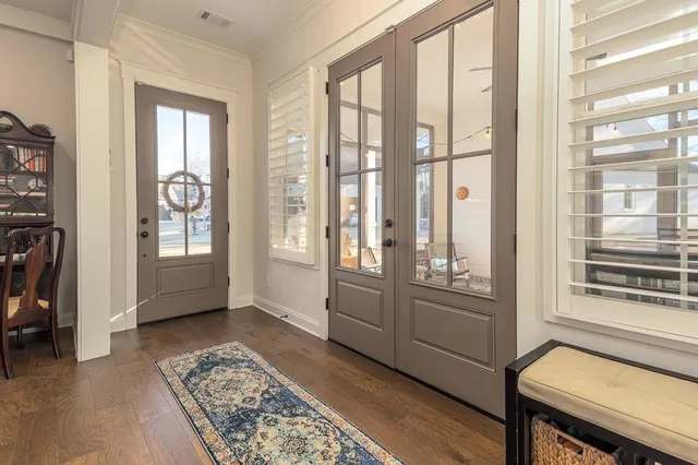 a living room with furniture kitchen view and a wooden floor