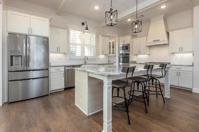 a kitchen with cabinets stainless steel appliances and a window