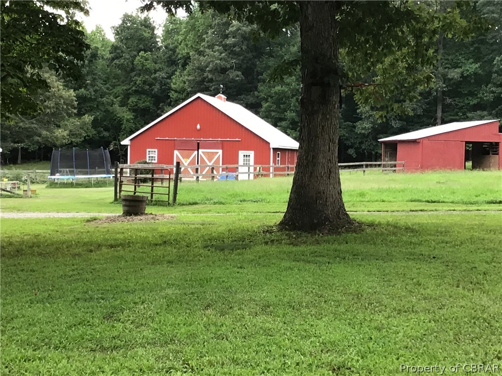 9924 Squirrel Run Road Gloucester, VA 23061 - Photo 11 of 37 View of yard featuring an outdoor structure and a trampoline