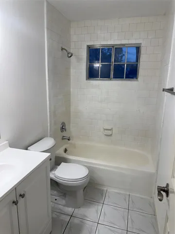 a white toilet sitting next to a bath tub