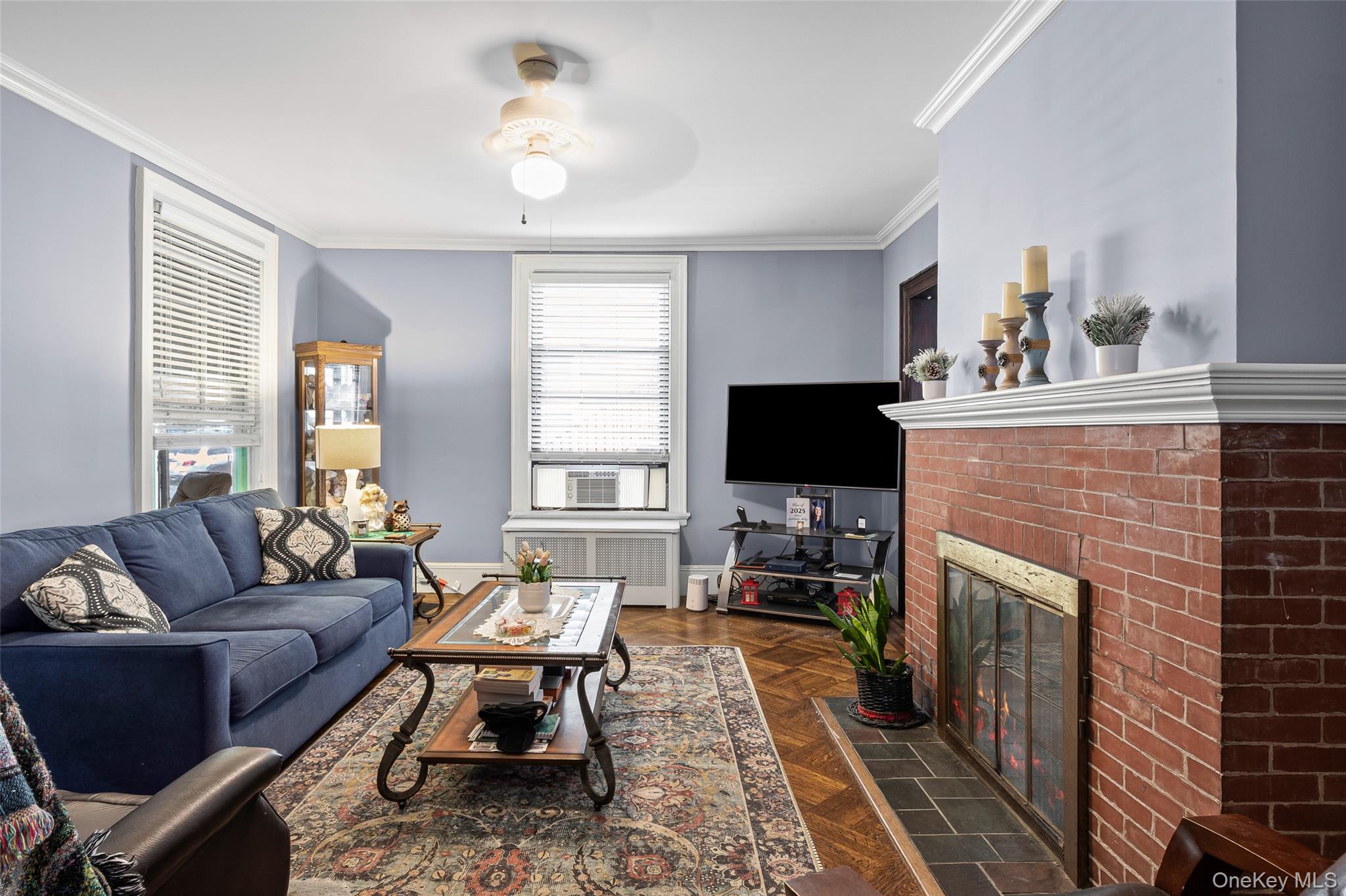 42-15 204th Street Queens, NY 11361 - Photo 7 of 23 a living room with furniture a flat screen tv and a fireplace