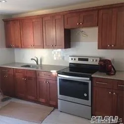 a kitchen with granite countertop wood cabinets and stainless steel appliances