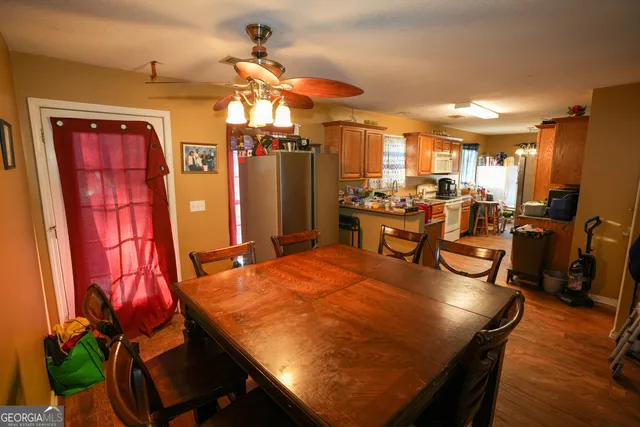 a dining room with furniture a chandelier and wooden floor