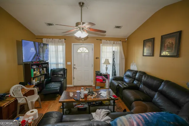 a living room with furniture chess board and a chandelier