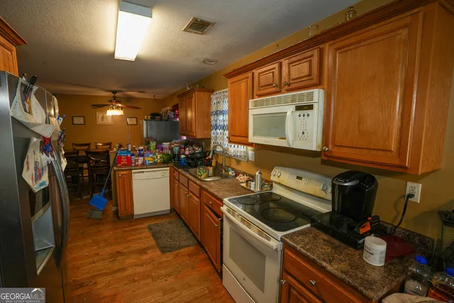 a kitchen that has a sink cabinets counter space and appliances