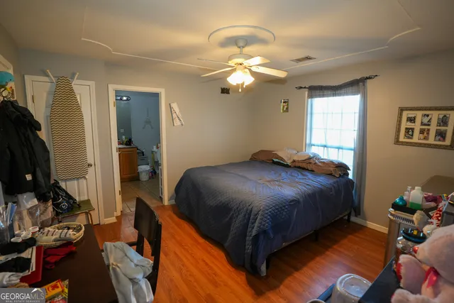 a bedroom with a bed and wooden floor