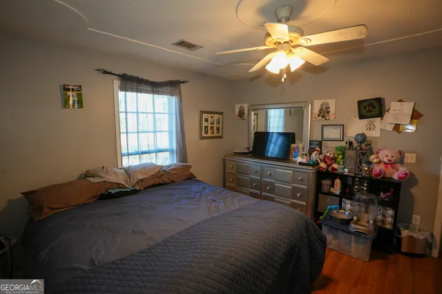 a bedroom with a bed and wooden floor