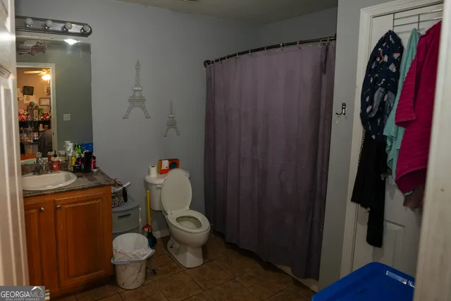 a bathroom with a toilet and a shower curtain