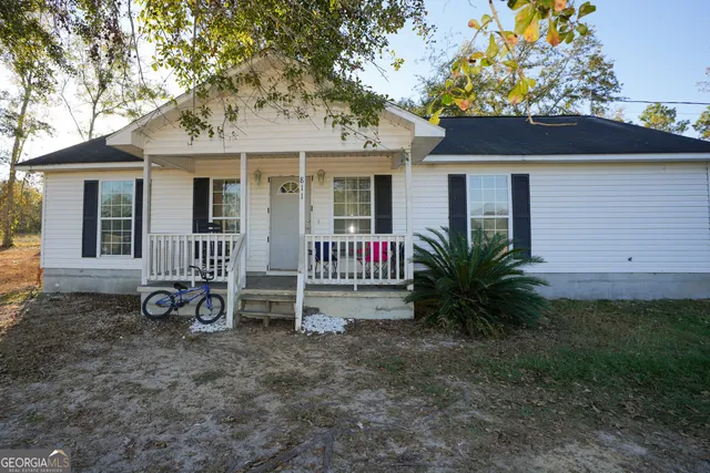 a view of a house with a yard and potted plants