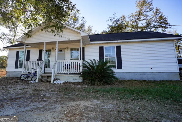 a view of a house with a yard and sitting area