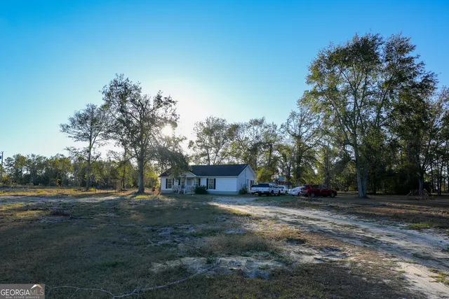 a view of a field with trees in background