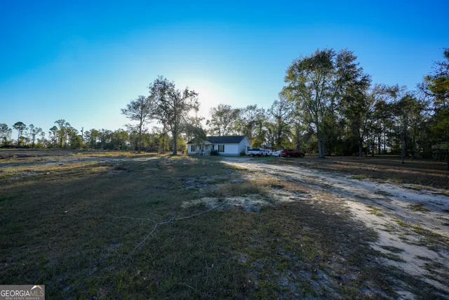 a view of dirt field with trees
