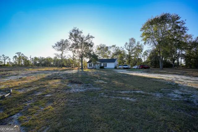 a view of dirt road with a building in the background