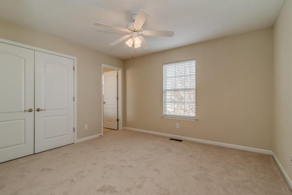 284 Meigs Drive, Unit E39 Murfreesboro, TN 37128 - Photo 12 of 15 an empty room with chandelier fan and windows