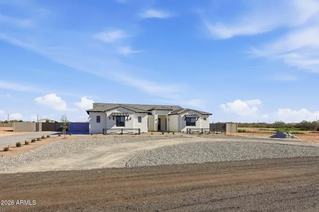 a view of a house with a big yard and large trees