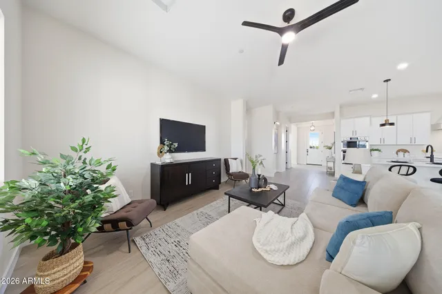 a view of a room with wooden floor a ceiling fan and windows