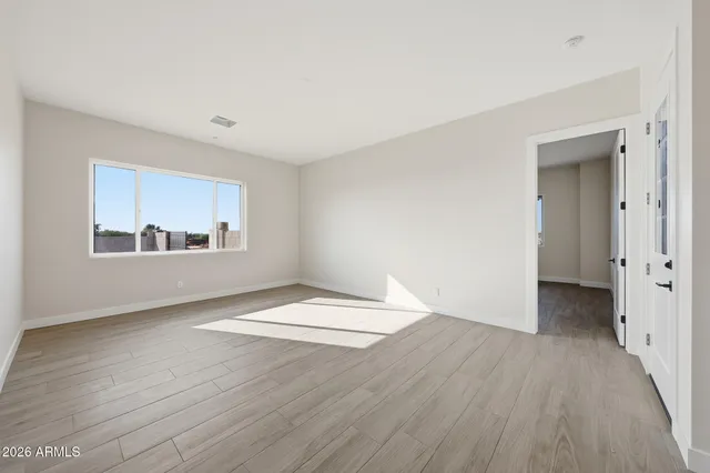 a view of an empty room with wooden floor
