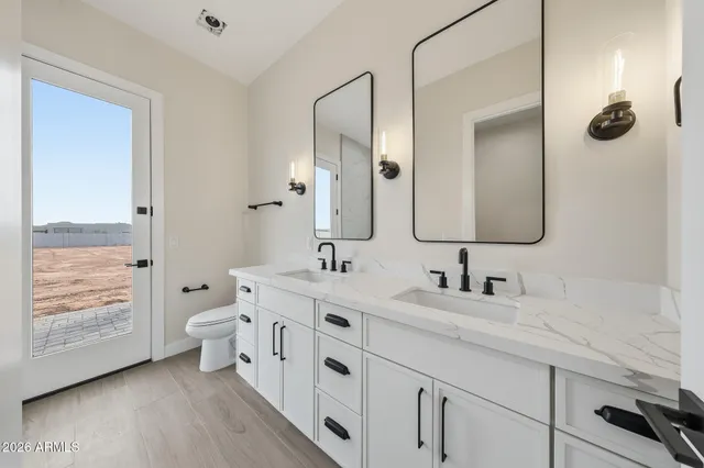 a bathroom with a granite countertop sink mirror and toilet