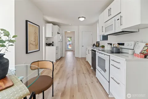a kitchen with a sink a stove a refrigerator cabinets and dining table