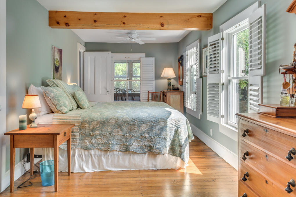240 Robbins Hill Road Brewster, MA 02631 - Photo 20 of 35 a spacious bedroom with a large bed and a chandelier